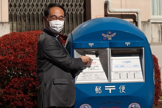埼玉150周年記念ポスト除幕式でポストに郵便物をいれる知事