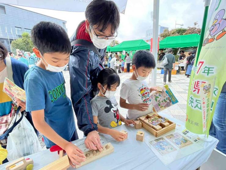 木のおもちゃで遊ぶ家族