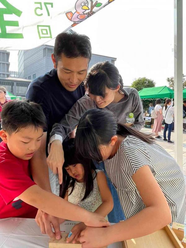 木のおもちゃで遊ぶ家族2