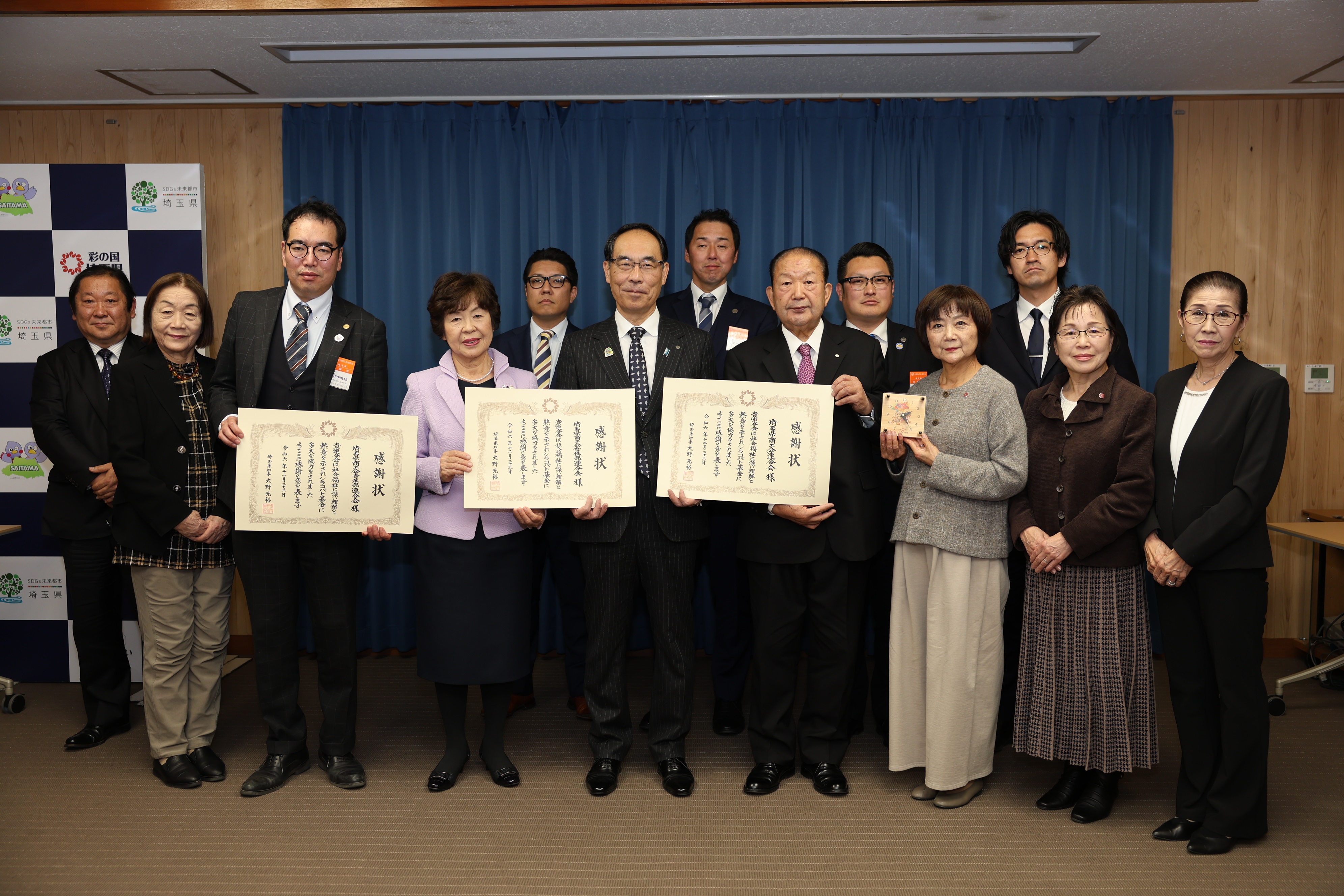 感謝状贈呈式で訪問者と集合写真を撮る知事の写真