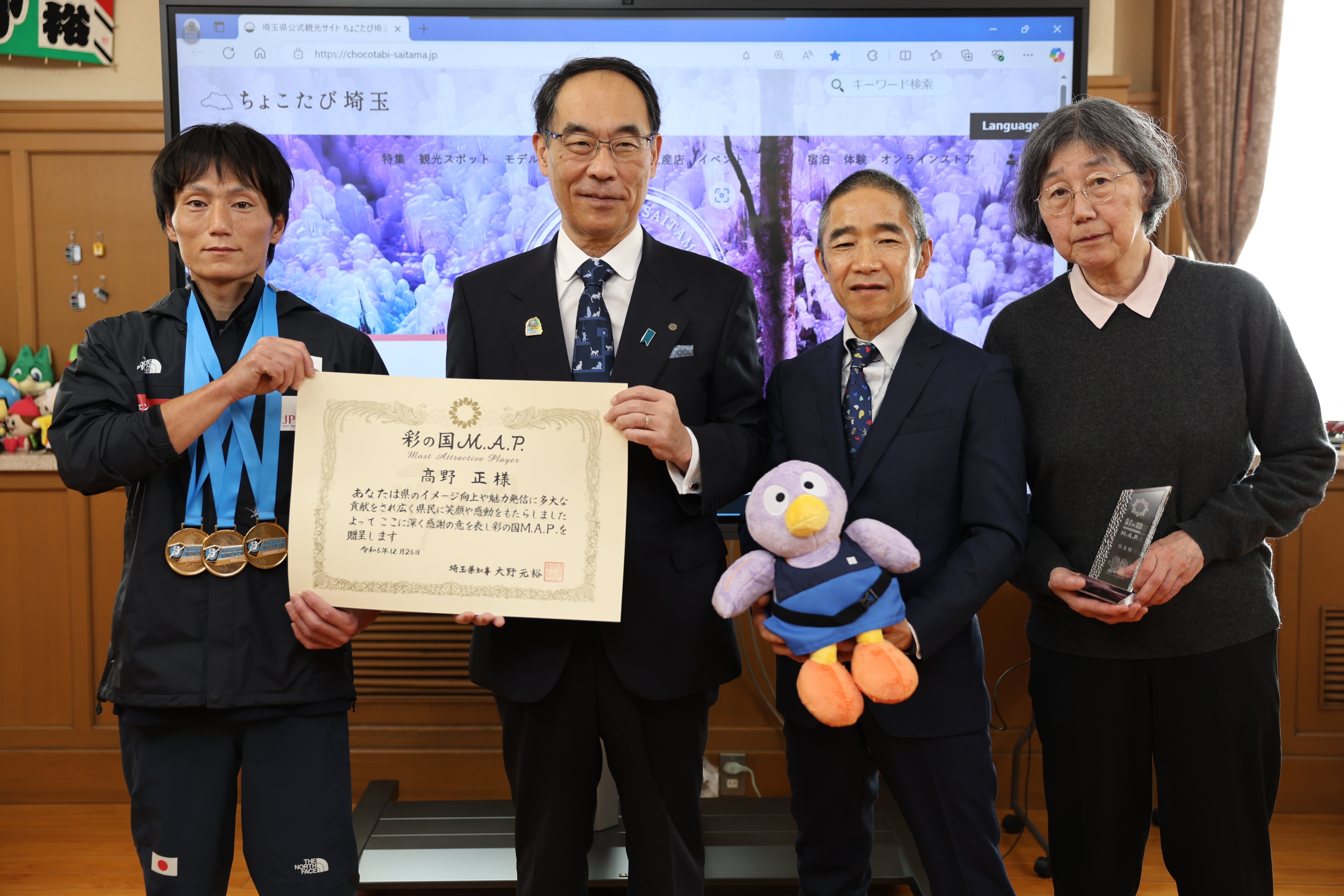 表敬訪問で訪問者と集合写真を撮る知事の写真