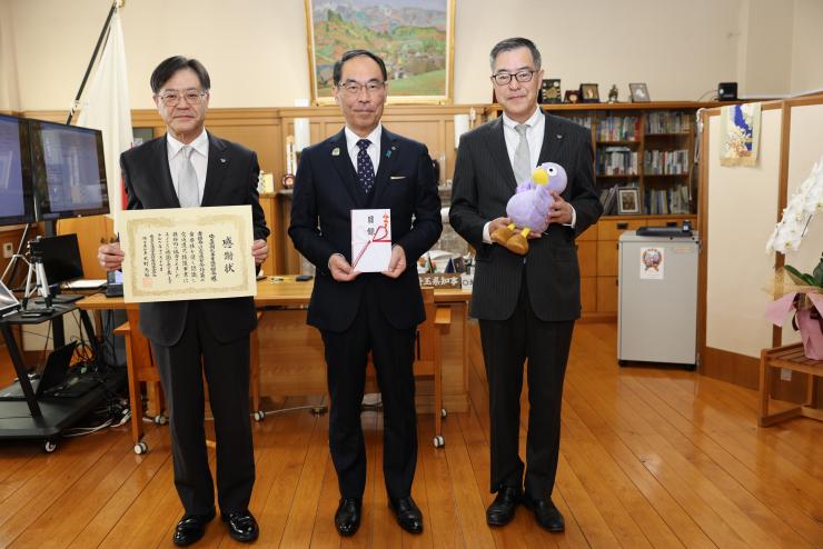 感謝状贈呈式で訪問者と記念撮影をする知事の写真