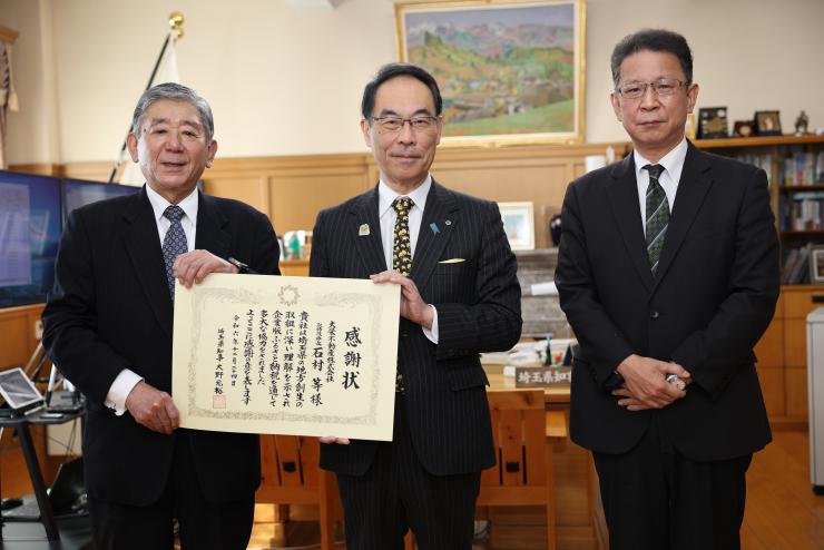 感謝状贈呈式で訪問者と記念撮影をする知事の写真
