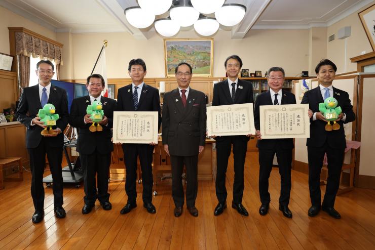 感謝状贈呈式で訪問者と記念撮影をする知事の写真