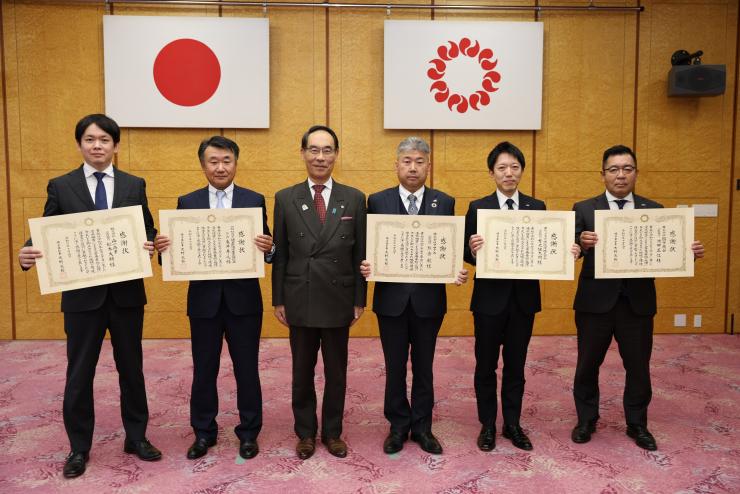 感謝状贈呈式で訪問者と記念撮影をする知事の写真