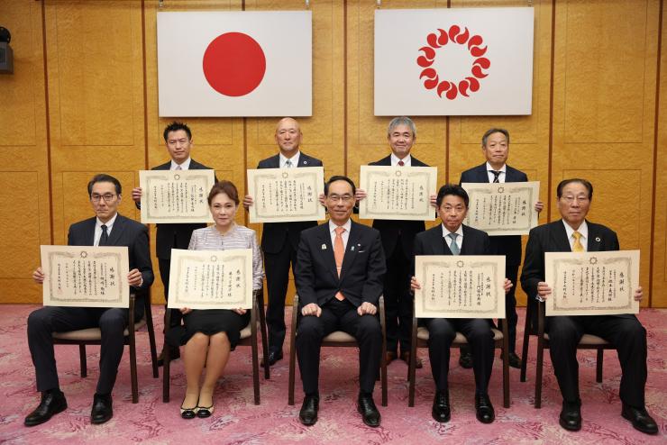 感謝状贈呈式で訪問者と記念撮影をする知事の写真