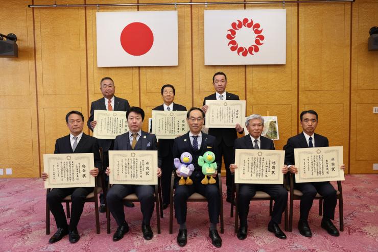 感謝状贈呈式で訪問者と記念撮影をする知事の写真