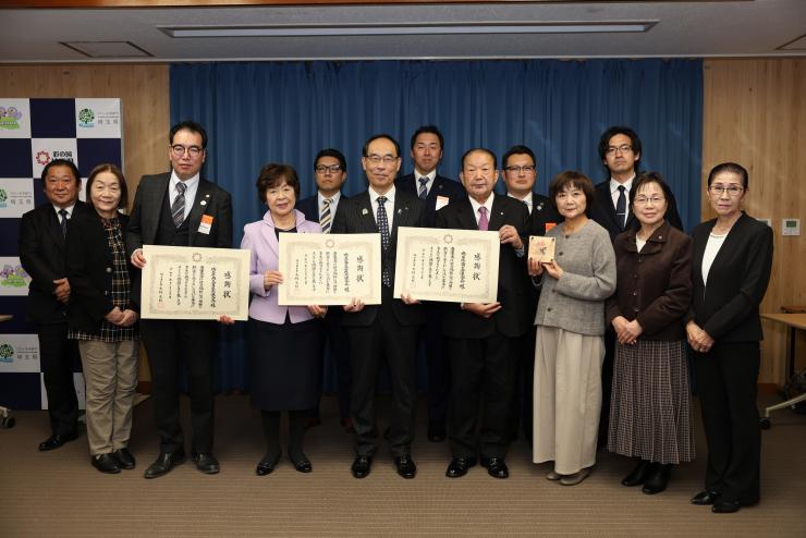 感謝状贈呈式で訪問者と記念撮影をする知事の写真