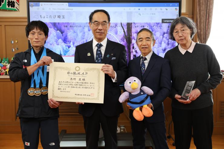 表敬訪問で訪問者と集合写真を撮る知事の写真