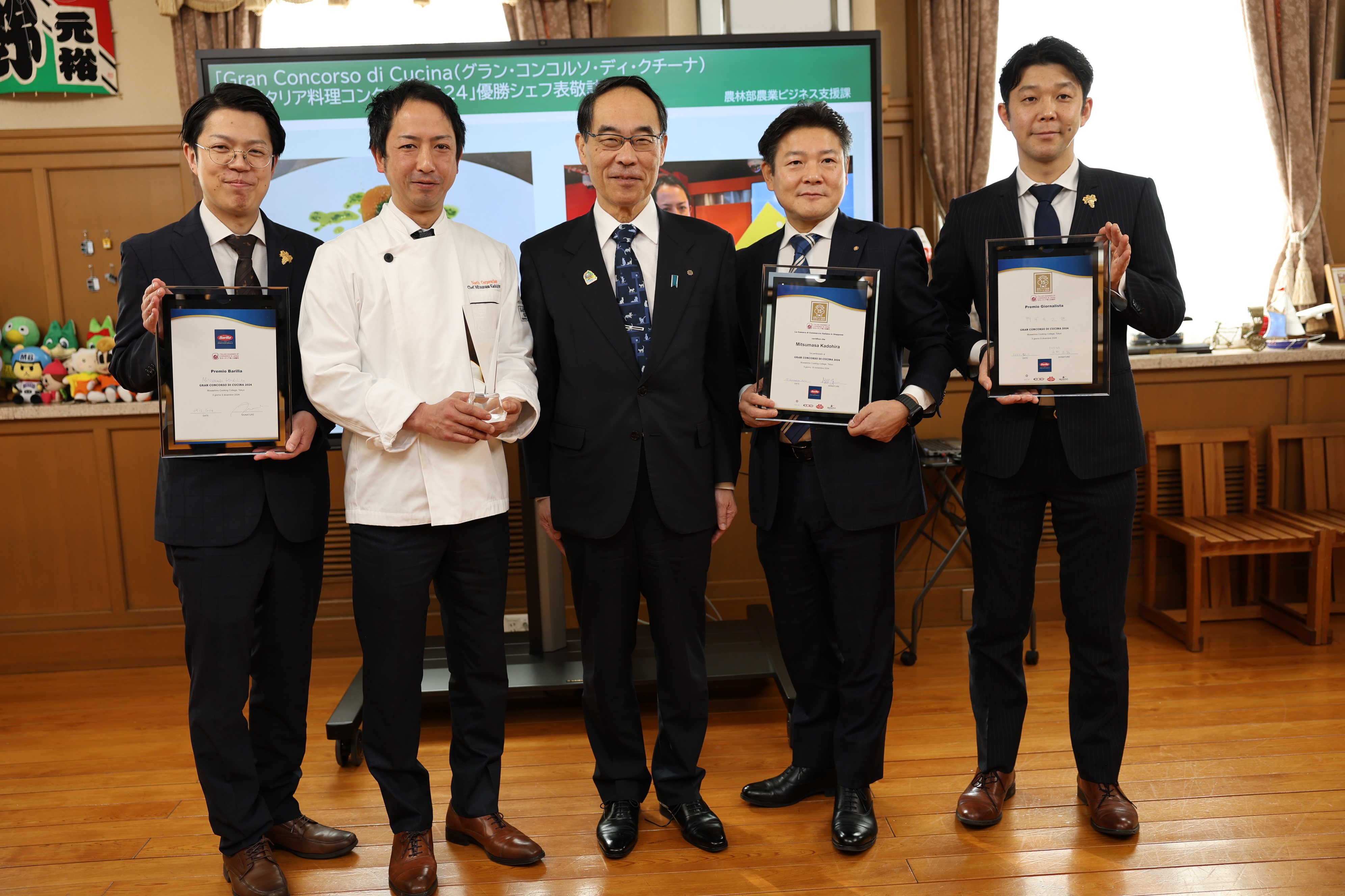 表敬訪問で訪問者と集合写真を撮る知事の写真