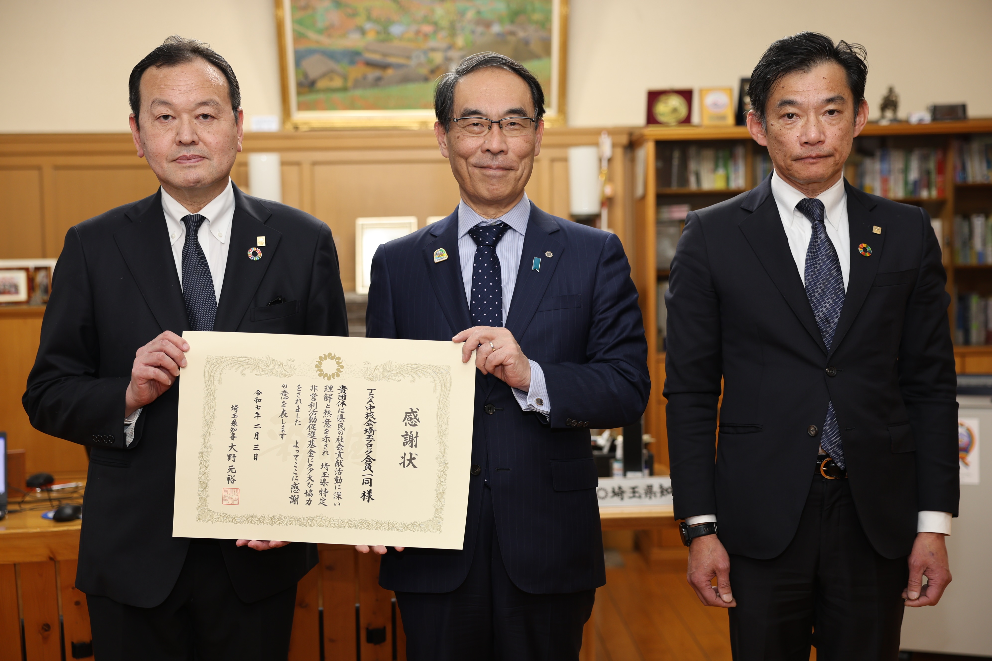 感謝状贈呈式で訪問者と集合写真を撮る知事の写真