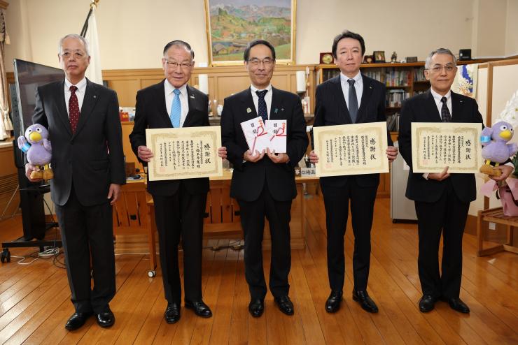 感謝状贈呈式で訪問者と記念撮影をする知事の写真