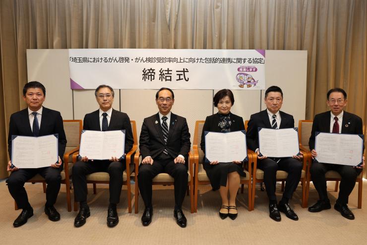 贈呈式で集合写真を撮る知事の写真