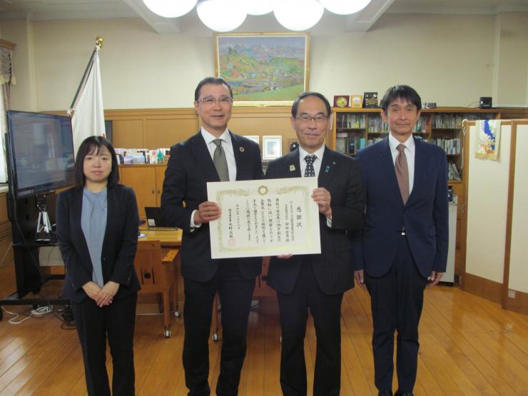 感謝状贈呈式で訪問者と記念撮影をする知事の写真