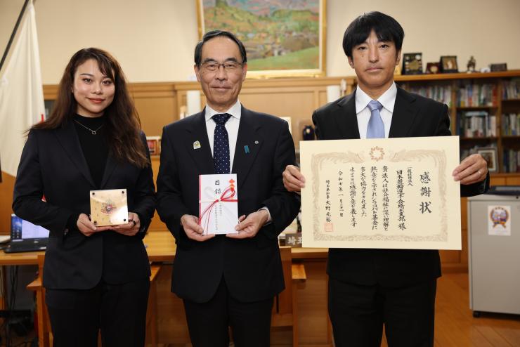 感謝状贈呈式で訪問者と記念撮影をする知事の写真