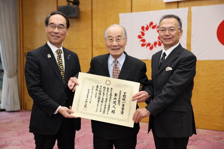 表彰式で訪問者と集合写真を撮る知事の写真