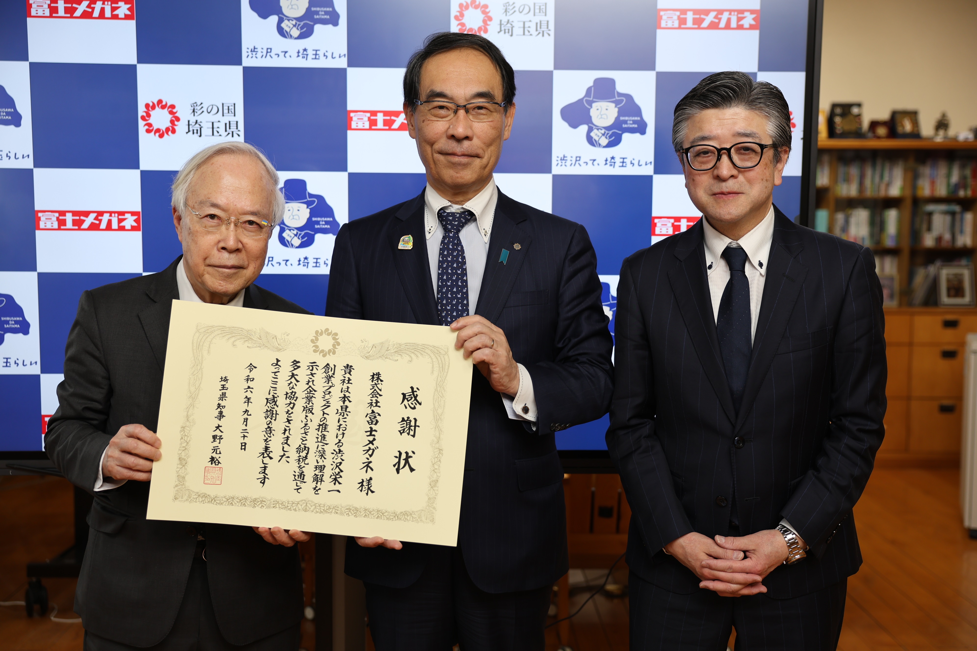 感謝状贈呈式で訪問者と集合写真を撮る知事の写真