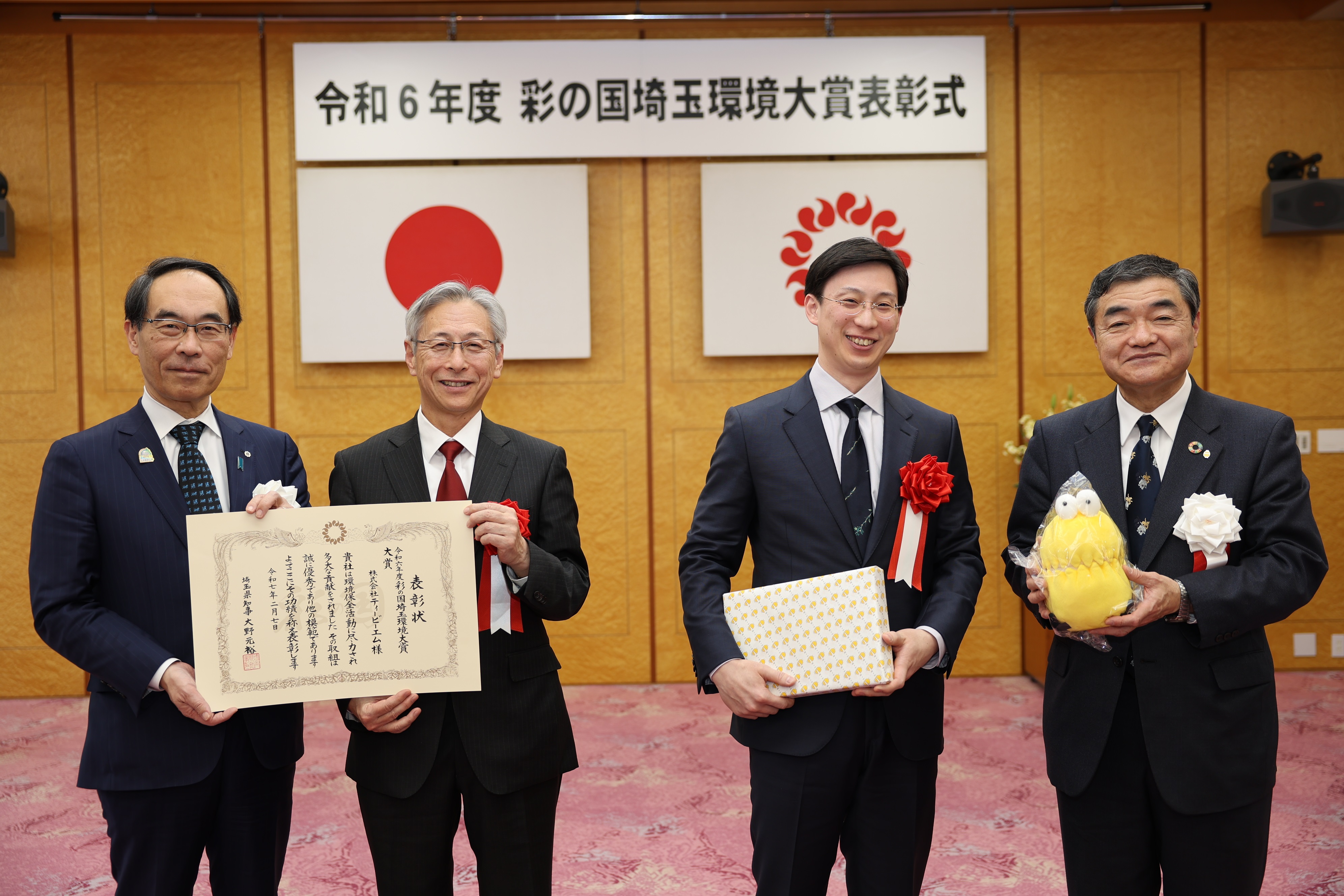 表彰式で株式会社ティービーエム関係者と記念撮影をする知事の写真