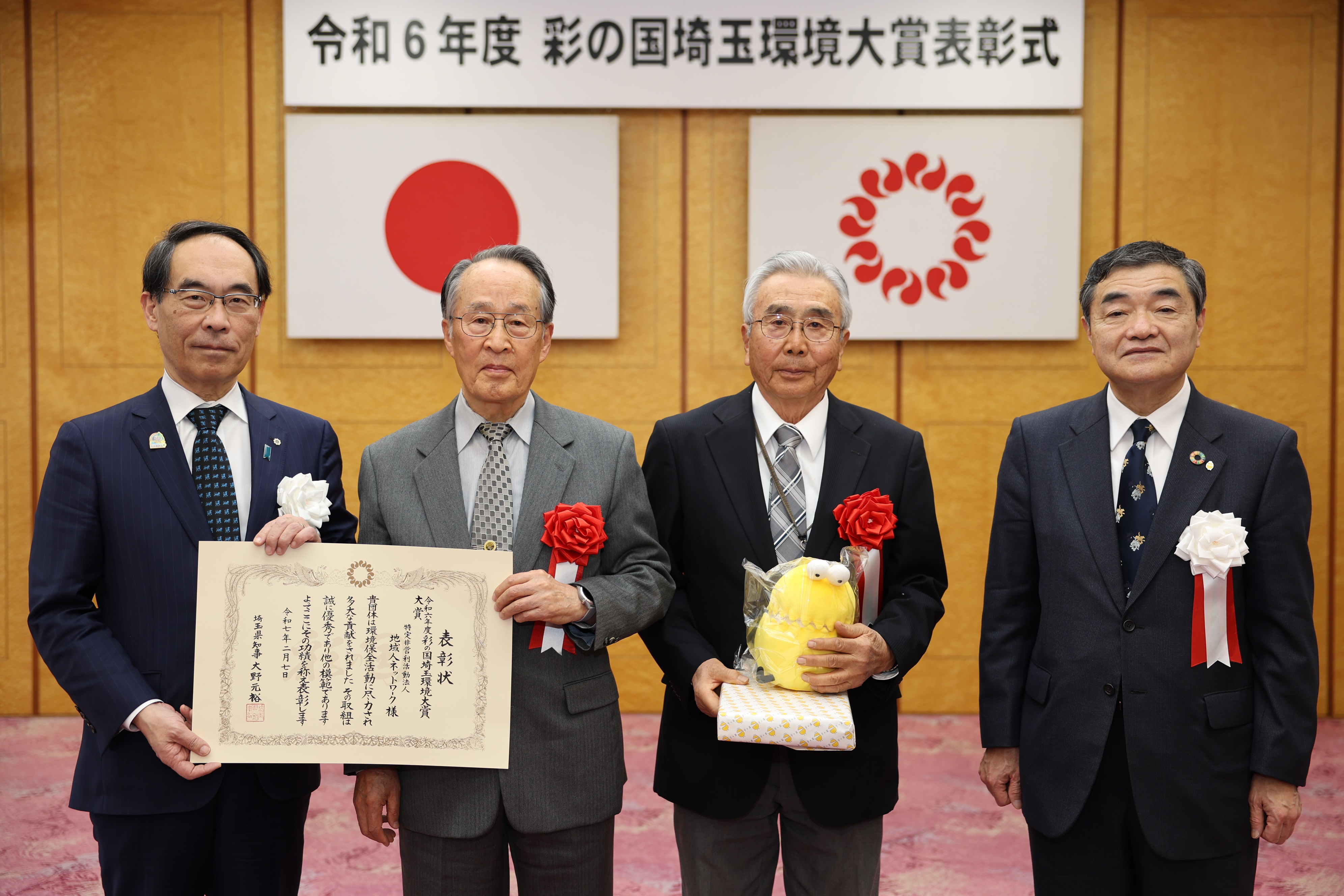 表彰式で地域人ネットワーク関係者と記念写真を撮る知事の写真