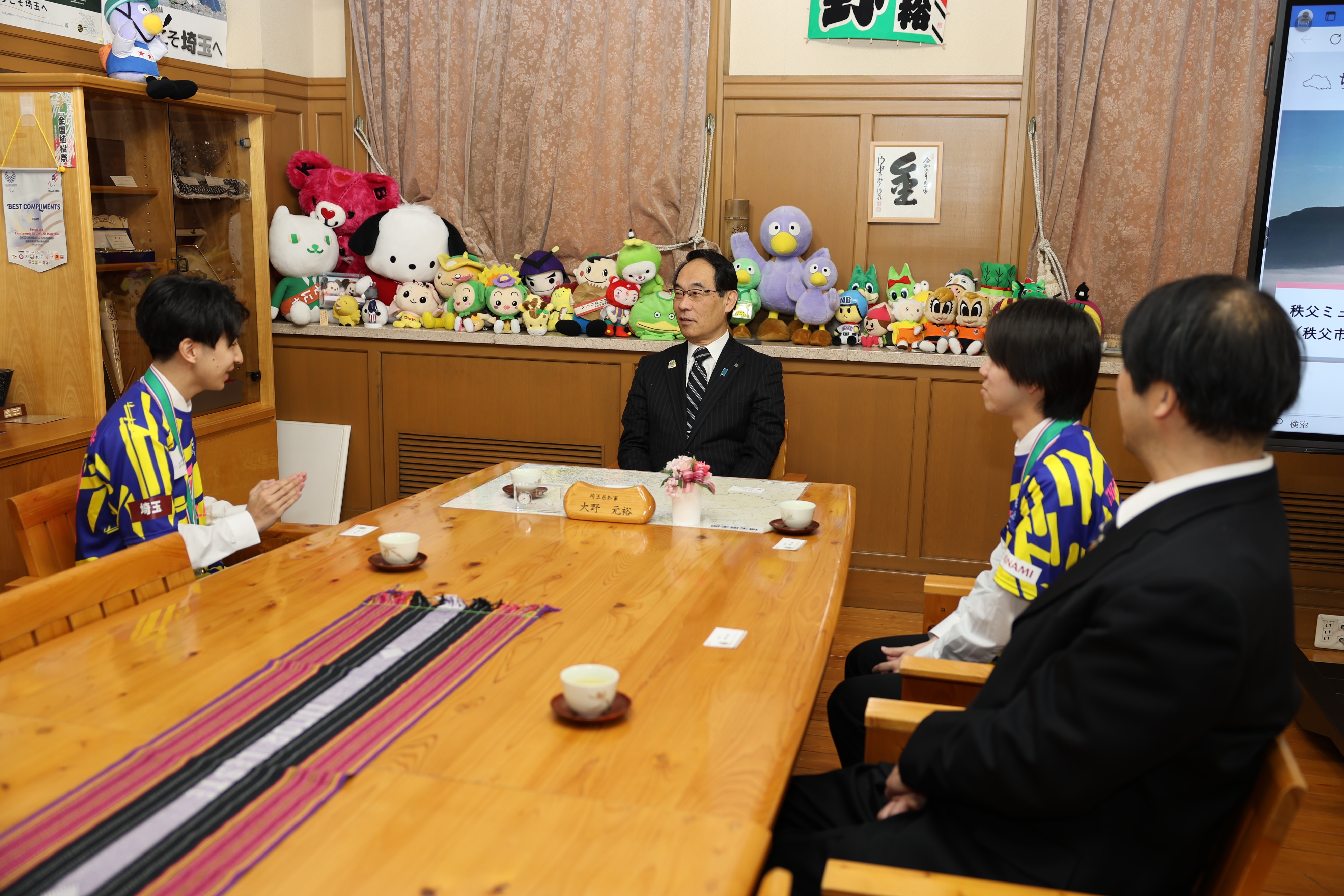 表敬訪問で訪問者と歓談する知事の写真