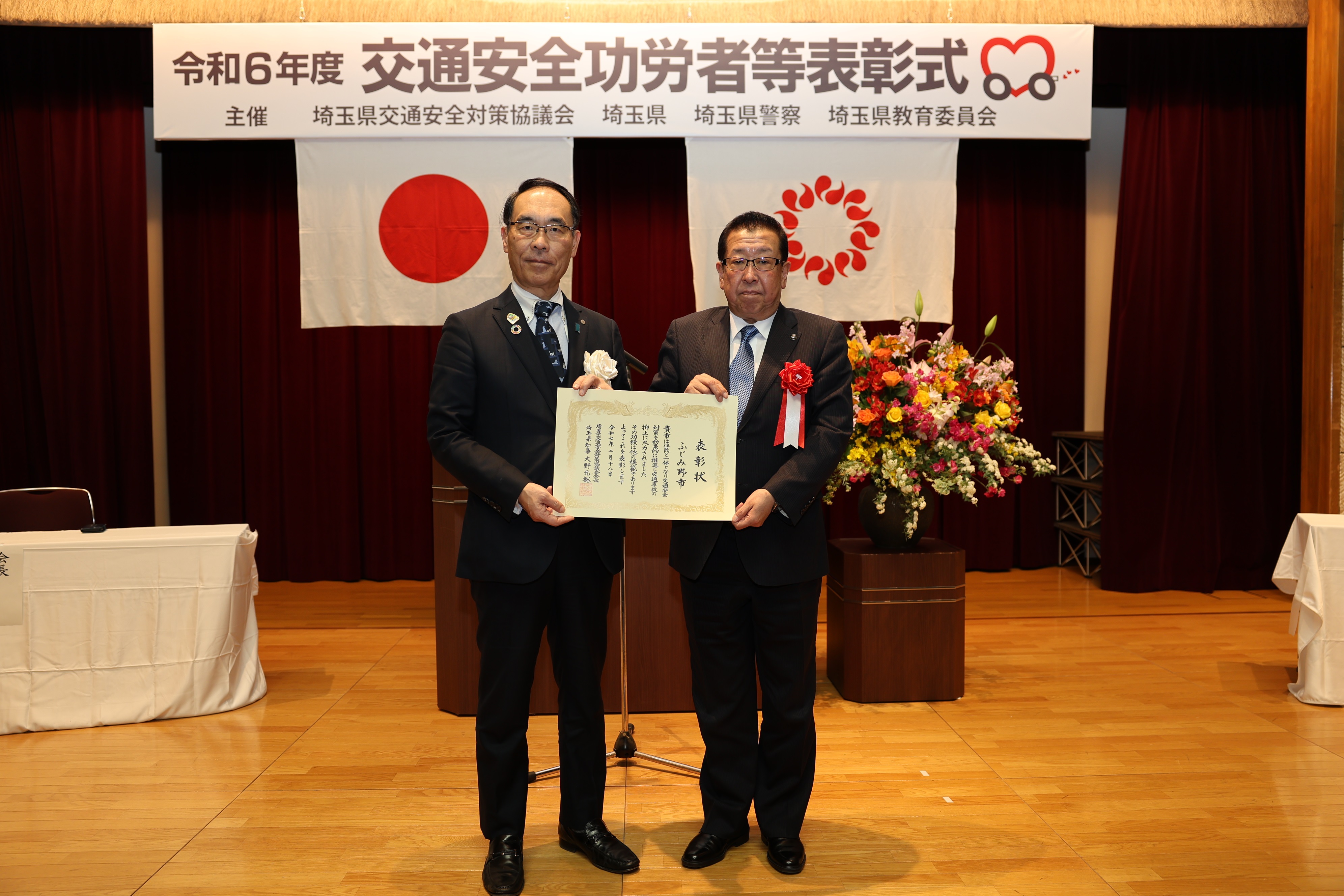表彰式で表彰者と記念写真を撮る知事の写真（知事と合わせて2名）
