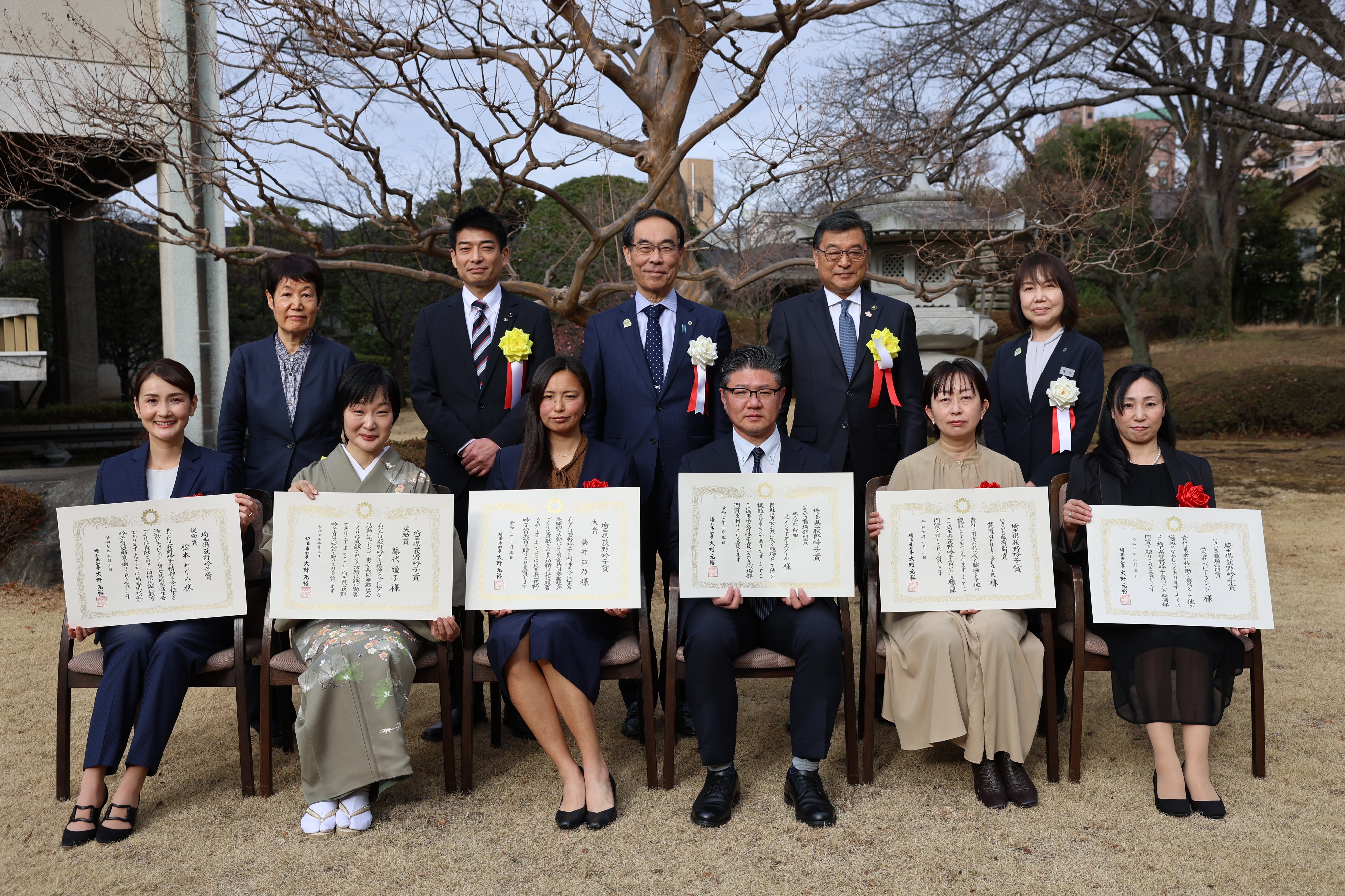 表彰式で表彰者と集合写真を撮る知事の写真