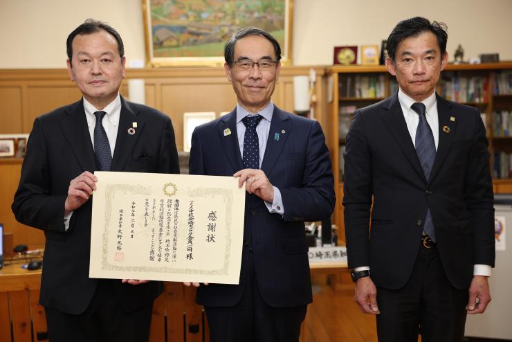 感謝状贈呈式で訪問者と集合写真を撮る知事の写真