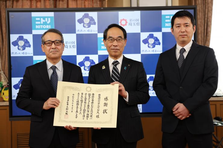 感謝状贈呈式で訪問者と記念撮影をする知事の写真