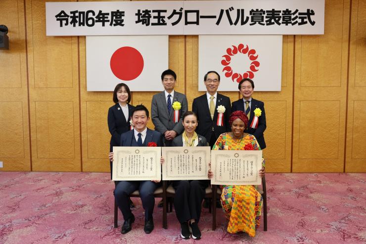 表彰式で訪問者と集合写真を撮る知事の写真