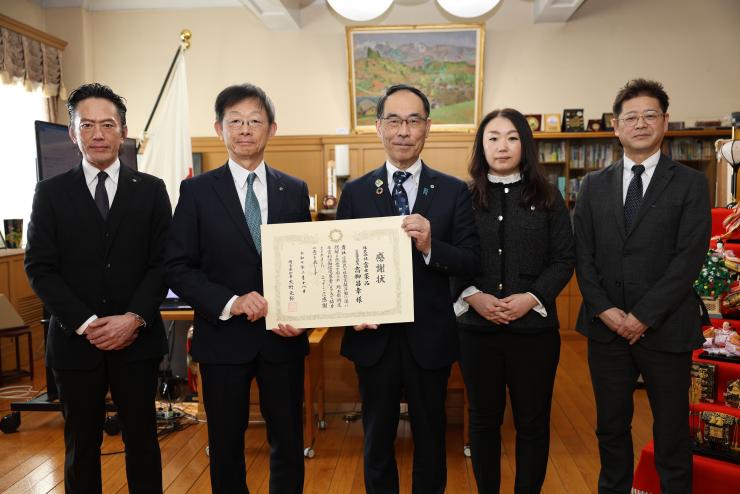 感謝状贈呈式で訪問者と記念写真を撮る知事の写真
