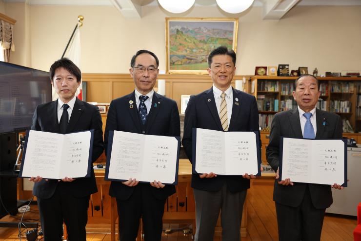締結式で訪問者と記念写真を撮る知事の写真