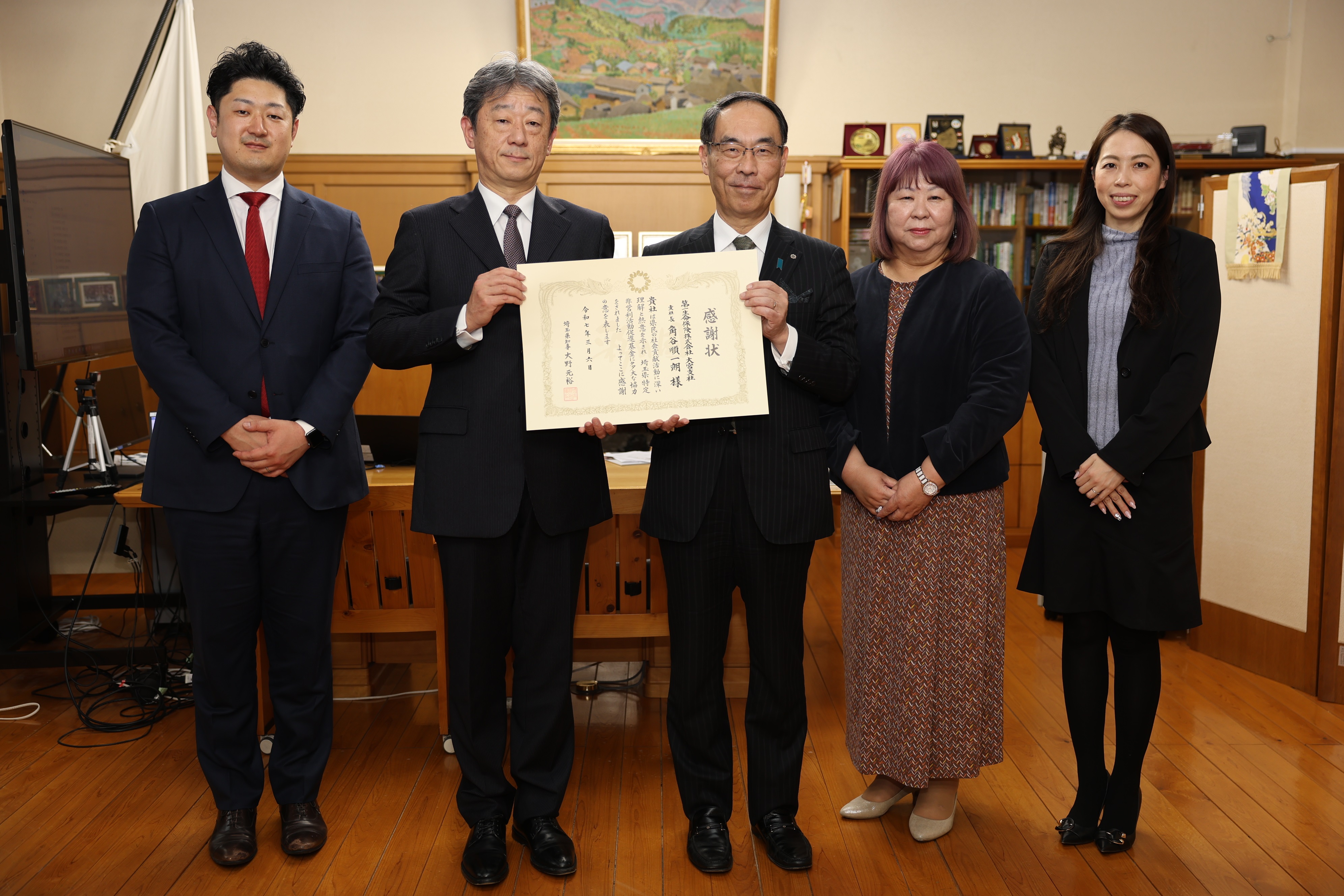 感謝状贈呈式で第一生命保険株式会社出席者と記念写真を撮る知事の写真