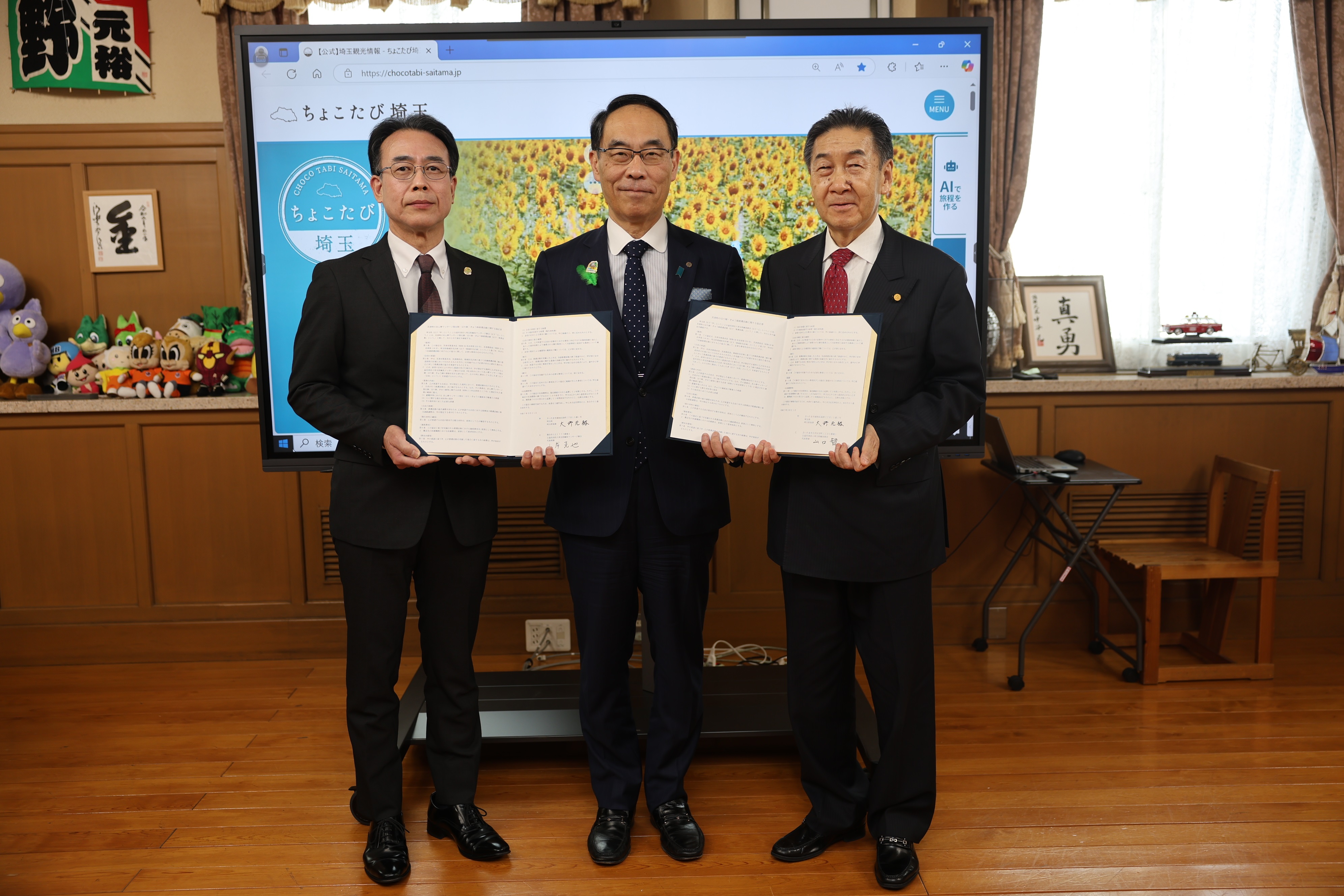 締結式で訪問者と記念写真を撮る知事の写真
